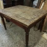 Early 1900s wooden table with pull-out extensions.